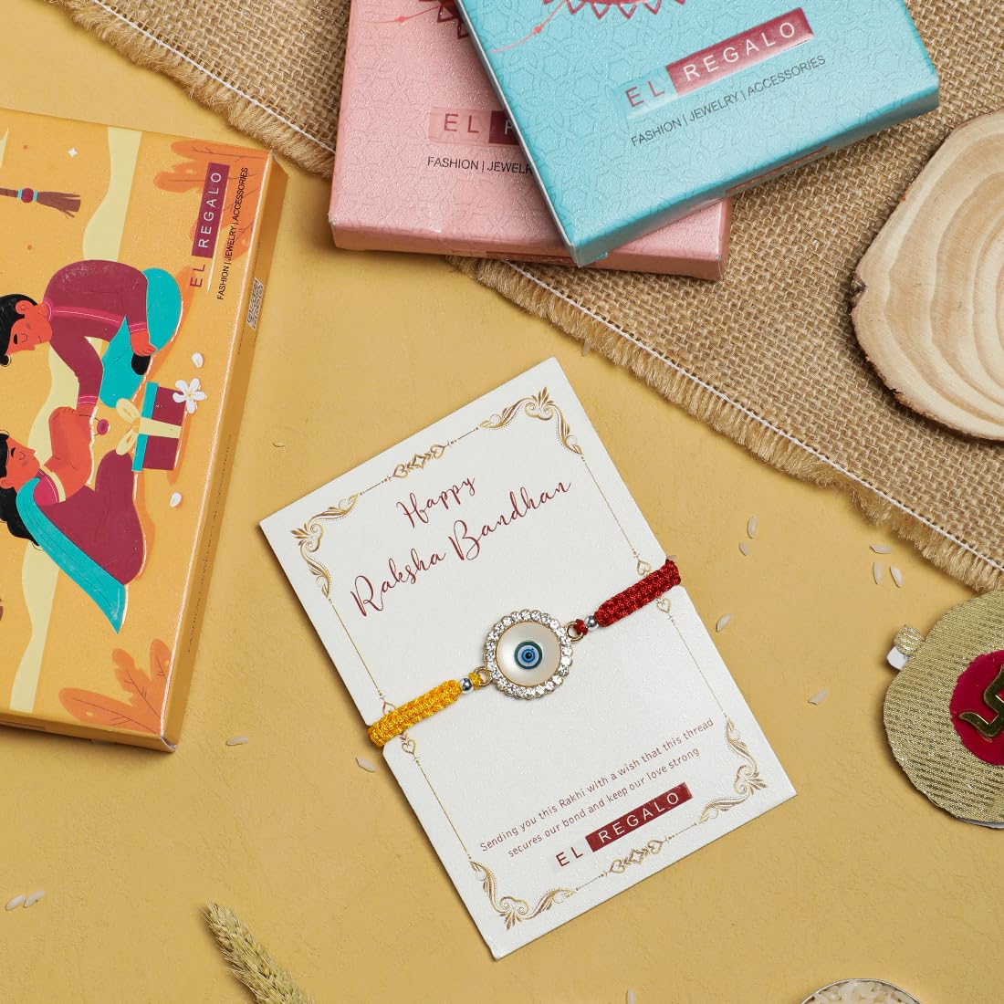 El Regalo 1PC Designer Evil Eye Red & Yellow Mauli Thread Rakhi for Brother - Rakshabandhan CZ Evil Eye Rakhi with Message Card & Roli Chawal in Rakhi Box for Bhaiya/Babhi/Bhatija/Bhatiji