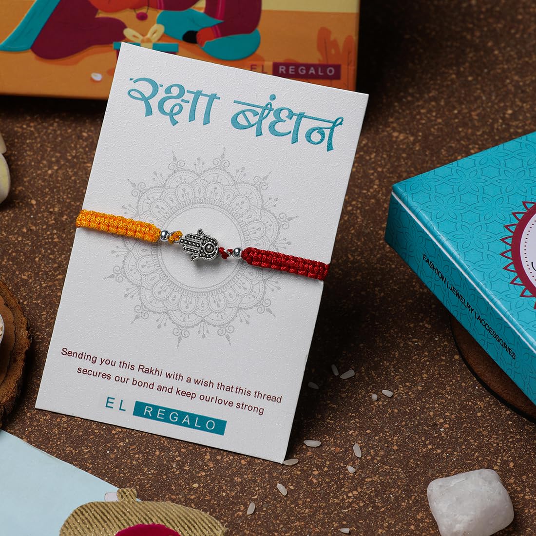 El Regalo 1 PC Designer Tassel Moli Rakhi, Hamsa Hand Moli Rakhi for Bhaiya - Rakshabandhan Red & Yellow Thread Rakhi with Message Card & Roli Chawal Shagun in Rakhi Box